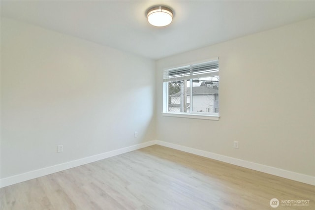 empty room featuring light wood finished floors and baseboards