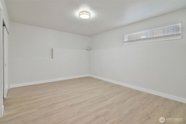 unfurnished room with light wood-style flooring and baseboards