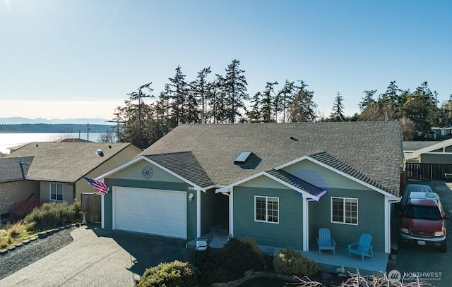 single story home featuring a shingled roof, concrete driveway, and an attached garage