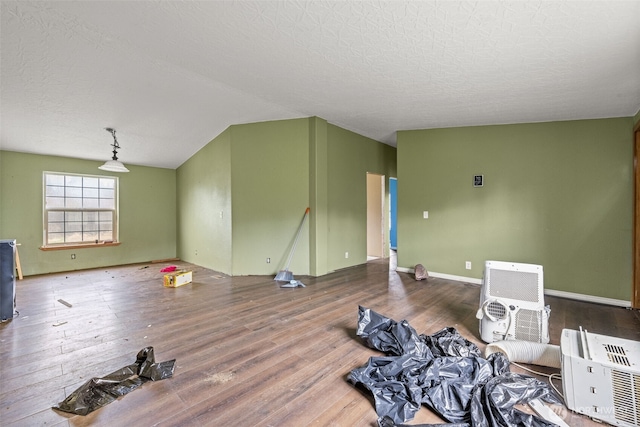 living area featuring lofted ceiling, a textured ceiling, and wood finished floors