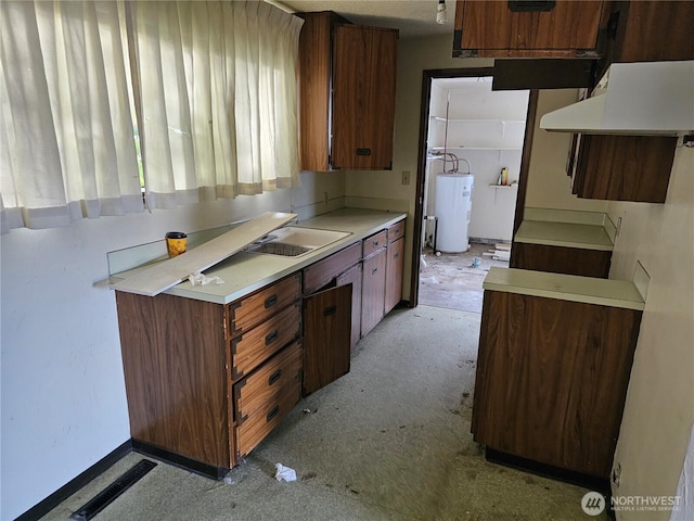 kitchen with water heater, light countertops, and a sink