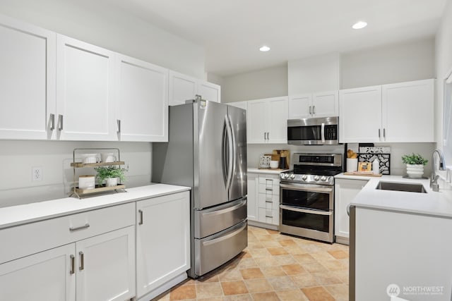 kitchen featuring white cabinets, stainless steel appliances, and a sink