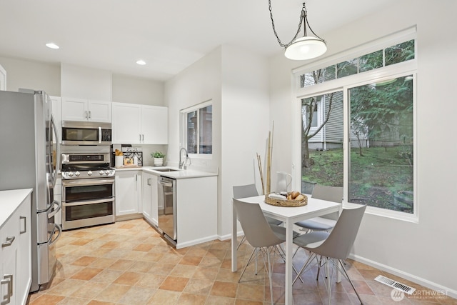 kitchen featuring stainless steel appliances, a healthy amount of sunlight, visible vents, and white cabinets