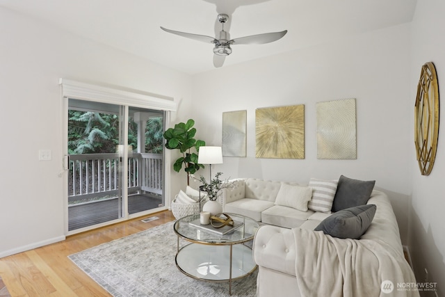 living area featuring visible vents, wood finished floors, a ceiling fan, and baseboards