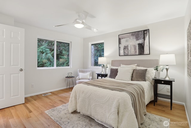 bedroom featuring visible vents, ceiling fan, baseboards, and wood finished floors