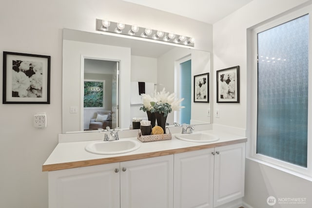 full bathroom with ensuite bathroom, double vanity, and a sink