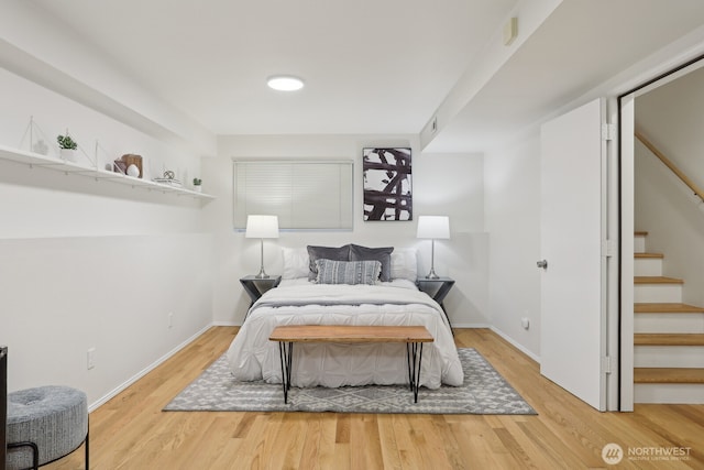 bedroom with visible vents, baseboards, and wood finished floors