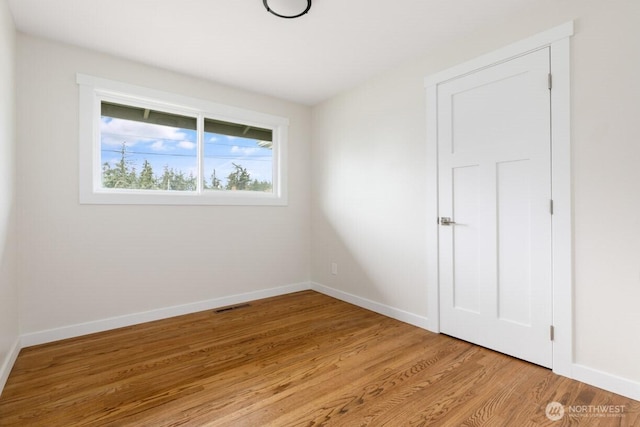 unfurnished room with light wood-style floors, baseboards, and visible vents