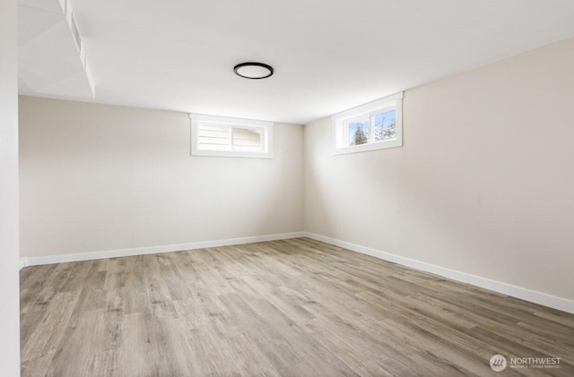 below grade area with baseboards and wood finished floors