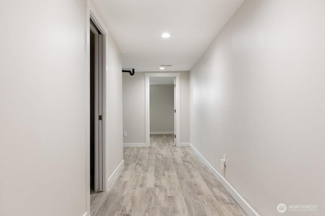 hall featuring light wood-style floors, visible vents, baseboards, and recessed lighting