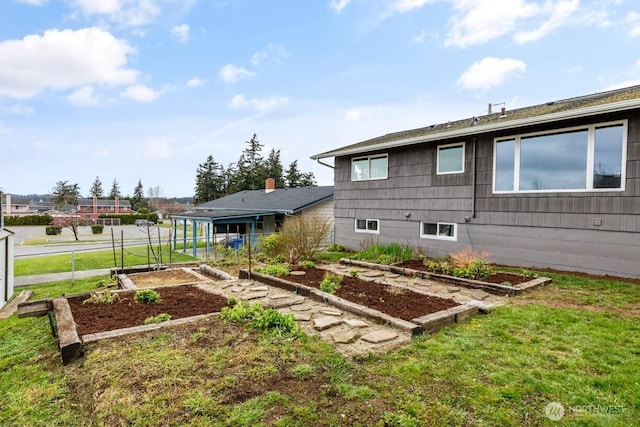 back of house featuring a garden, a yard, and fence