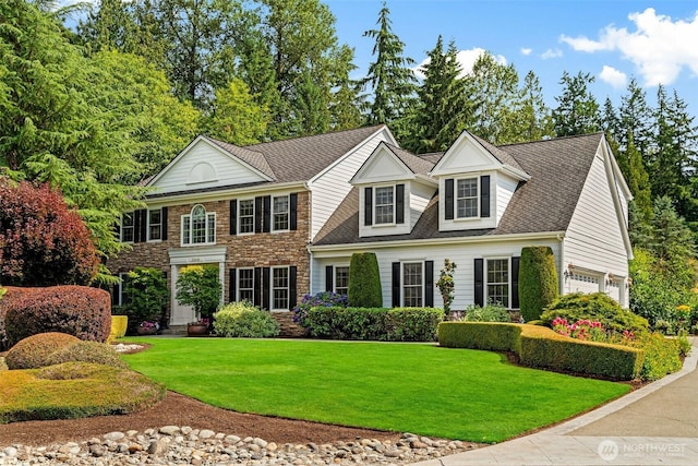 view of front facade featuring roof with shingles and a front lawn