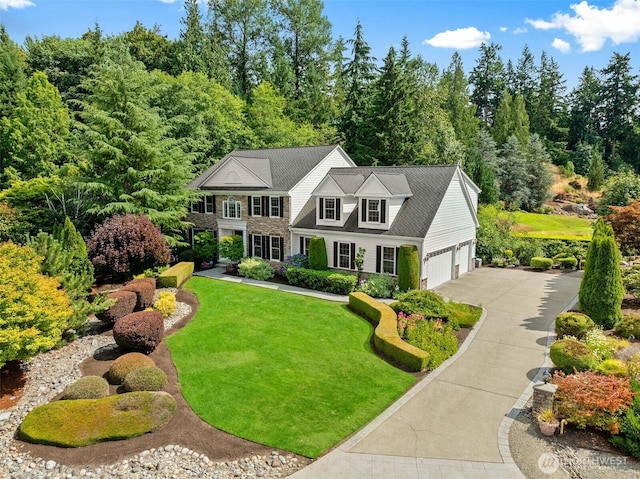 view of front of house featuring concrete driveway and a front yard