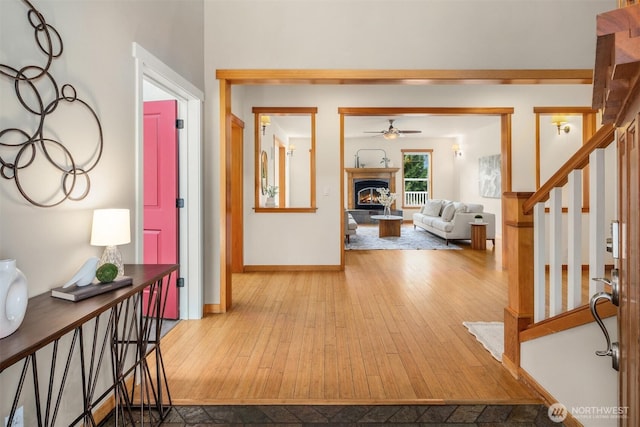 hall with baseboards, stairway, and hardwood / wood-style floors