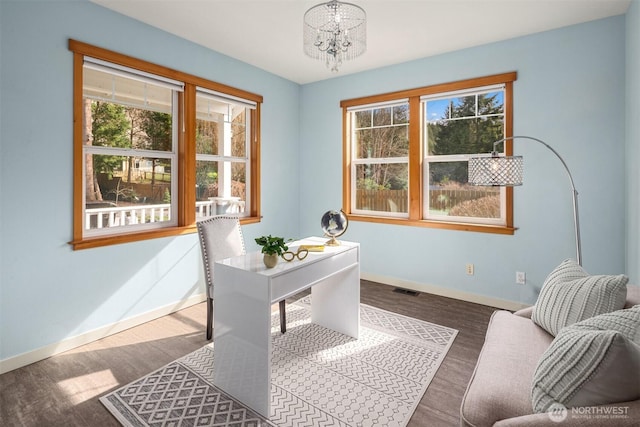 home office featuring a chandelier, wood finished floors, a wealth of natural light, and baseboards