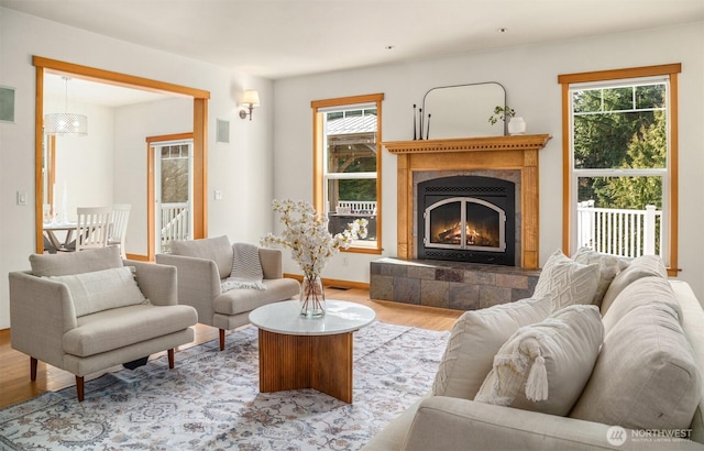 living area featuring a wealth of natural light, a fireplace, baseboards, and wood finished floors