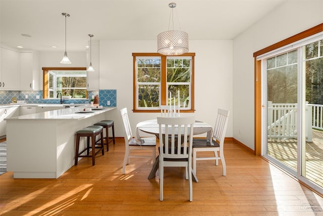 dining space with baseboards and light wood finished floors