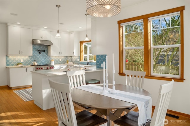 dining area featuring light wood finished floors, recessed lighting, visible vents, and baseboards