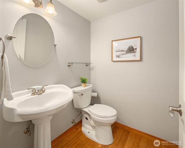 bathroom featuring wood finished floors, toilet, and baseboards