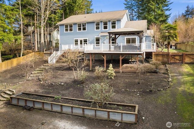 back of property with a gate, stairs, fence, and a gazebo