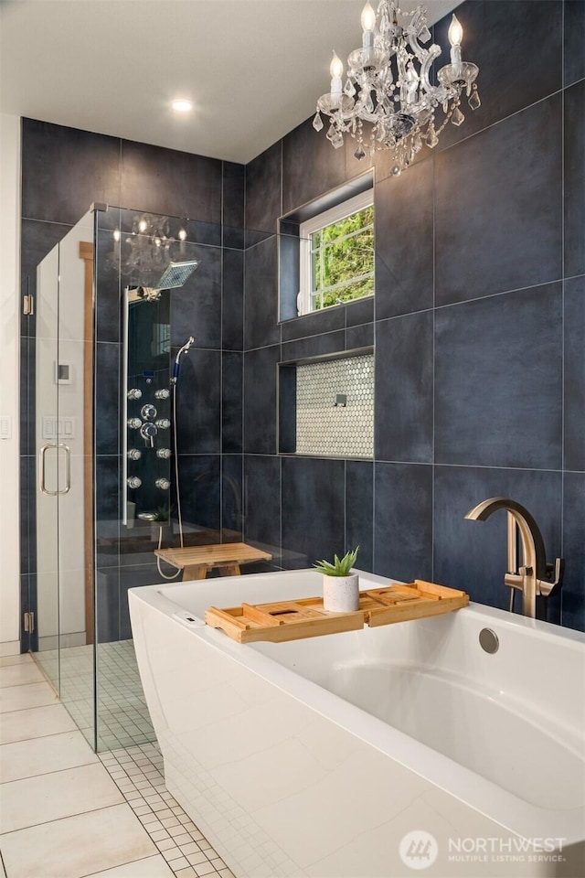 full bath featuring tile patterned flooring, a shower stall, a tub, and tile walls