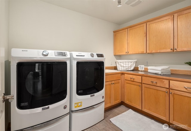 laundry area featuring visible vents, washing machine and clothes dryer, and cabinet space