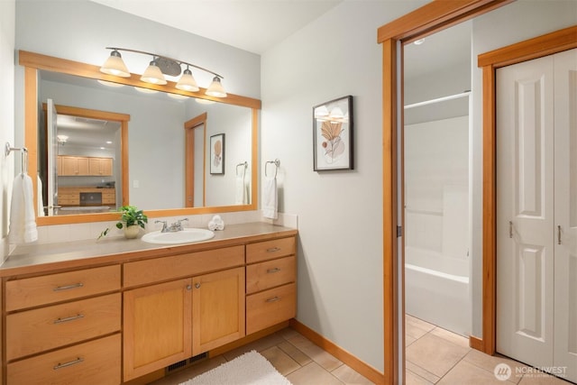 bathroom featuring visible vents, baseboards, tile patterned flooring, a washtub, and vanity