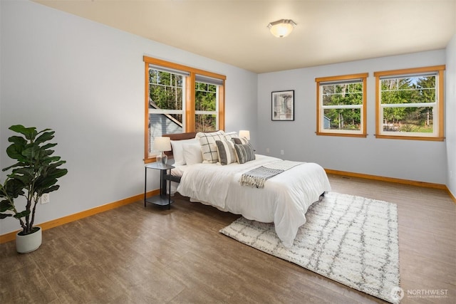 bedroom with baseboards and wood finished floors