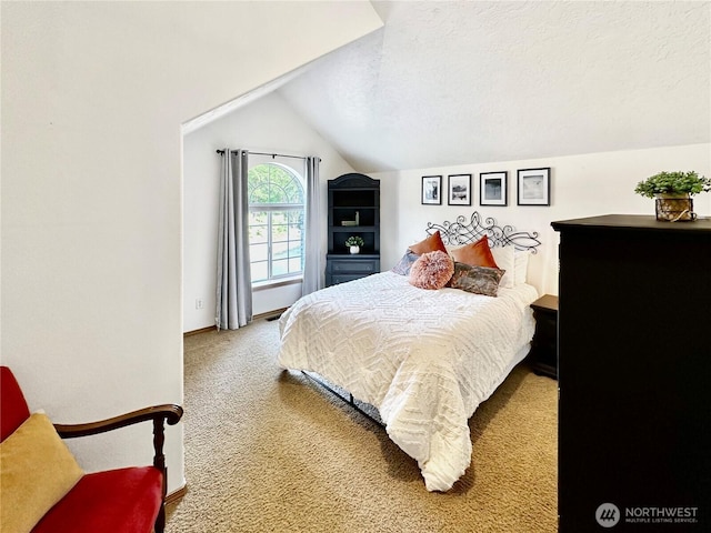 carpeted bedroom featuring vaulted ceiling, a textured ceiling, and visible vents