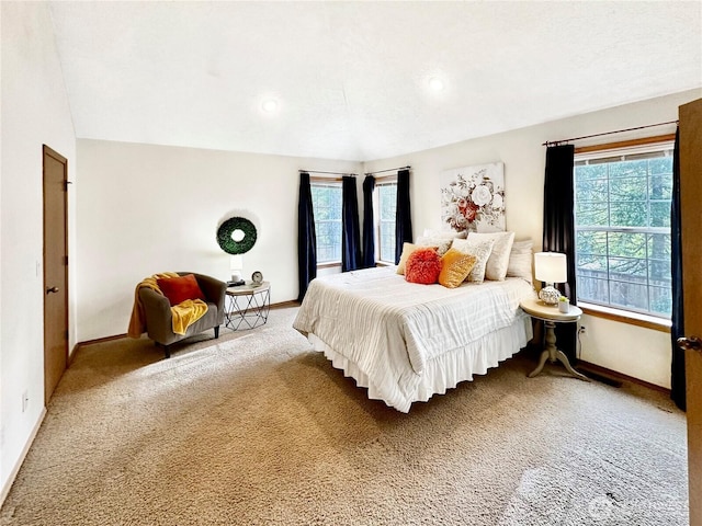 carpeted bedroom with baseboards and vaulted ceiling