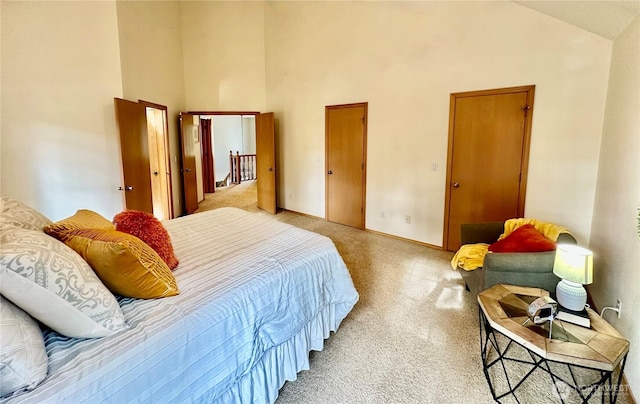 bedroom with baseboards, high vaulted ceiling, and light colored carpet