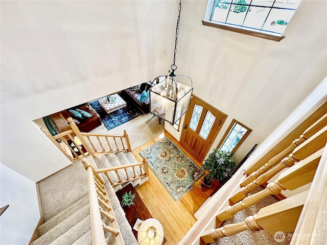 entryway with stairs, a high ceiling, and wood finished floors