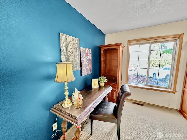 office space with baseboards, visible vents, vaulted ceiling, a textured ceiling, and carpet floors