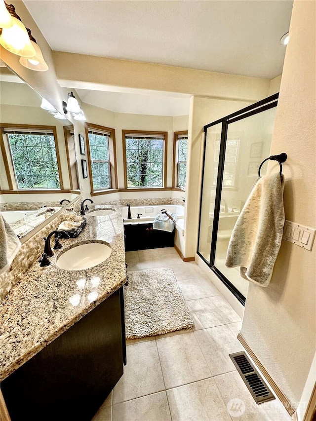 full bathroom with a stall shower, tile patterned flooring, a sink, and visible vents