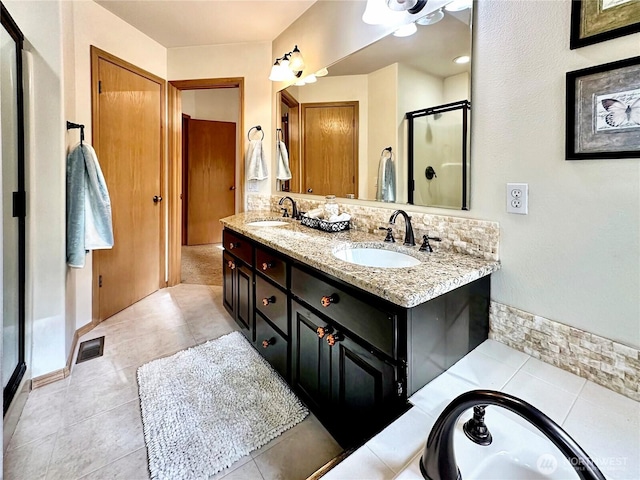 bathroom with visible vents, a sink, a shower stall, and double vanity