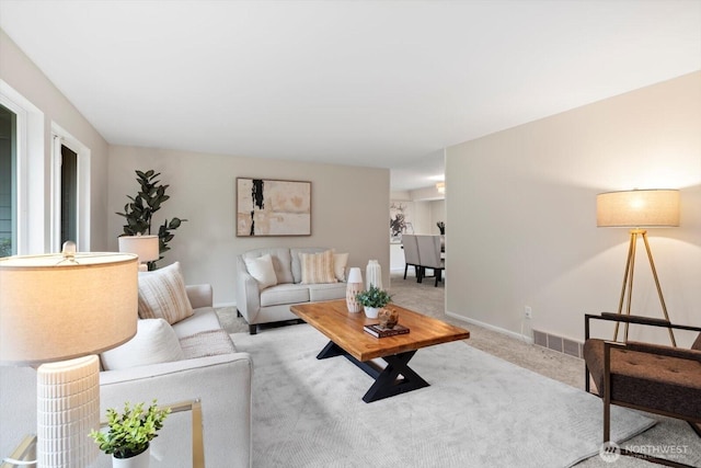 carpeted living room with visible vents and baseboards