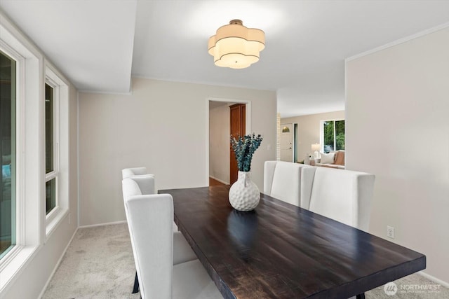 dining space with light carpet and baseboards