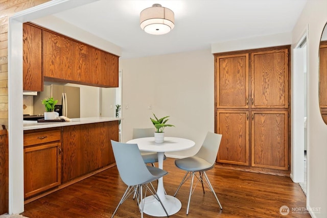 kitchen featuring brown cabinets, stainless steel fridge, and dark wood-style floors