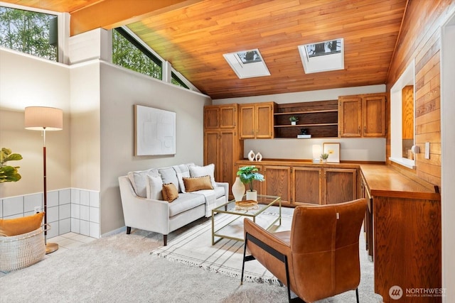 living area featuring light carpet, high vaulted ceiling, wooden ceiling, and a skylight