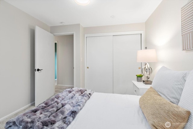 bedroom featuring carpet, baseboards, and a closet