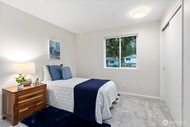 carpeted bedroom with a closet and baseboards