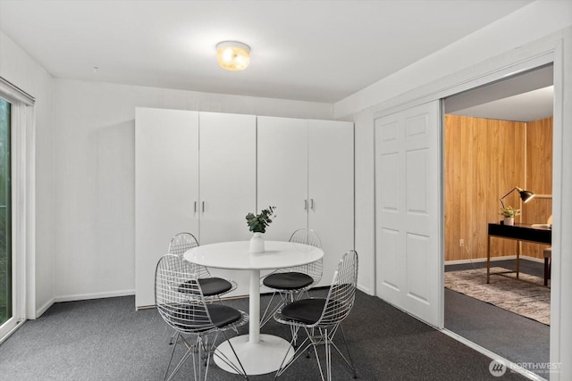 dining space featuring carpet and baseboards