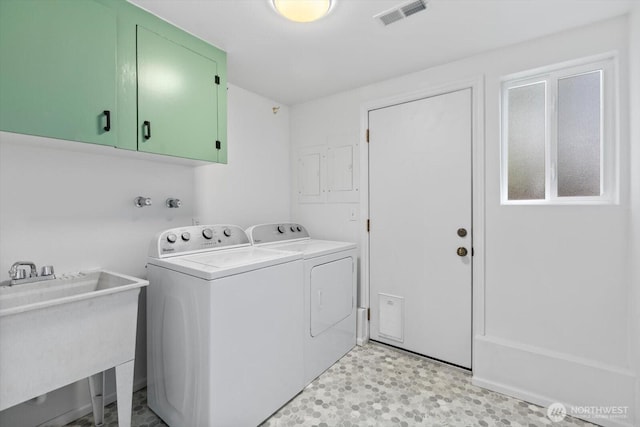 laundry room featuring cabinet space, visible vents, light floors, separate washer and dryer, and a sink