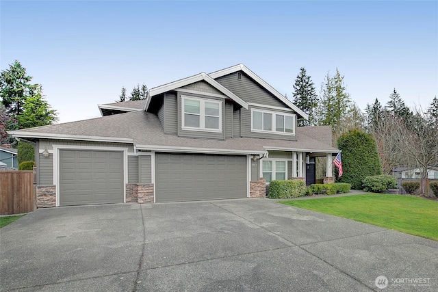 craftsman inspired home featuring a shingled roof, a front lawn, fence, concrete driveway, and stone siding