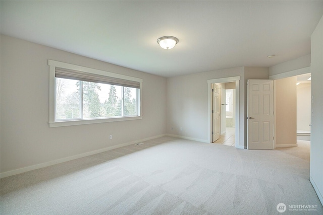 unfurnished bedroom with connected bathroom, baseboards, and carpet flooring