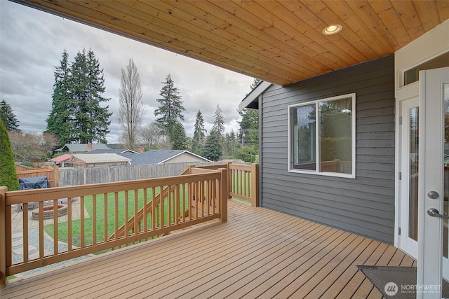 wooden terrace featuring a yard and fence