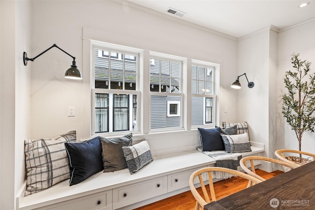 interior space with visible vents, wood finished floors, and ornamental molding