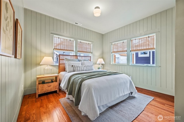 bedroom featuring wood-type flooring, visible vents, and baseboards