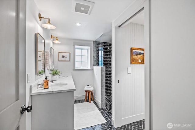 full bathroom with baseboards, visible vents, a shower, and vanity