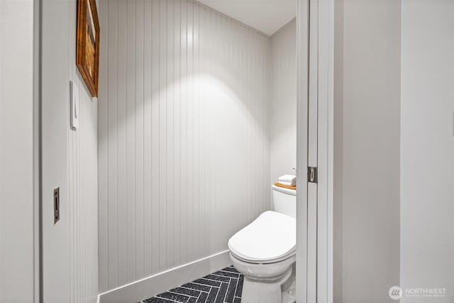 bathroom with baseboards and toilet